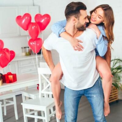 Romantisk og forelsket par med hjerteformede balloner i baggrunden